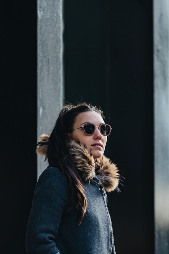Young woman wearing Shelter wooden sunglasses in front of La Maison des Créateurs